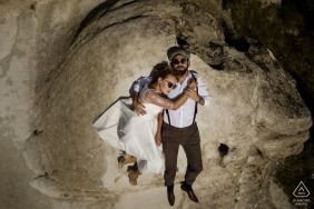 土耳其新娘和新郎，躺在岩石上，放松身心，参加卡帕多西亚的婚礼前订婚会议