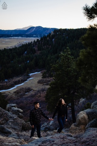 A couple climbing up a mountain at blue hour above the Spruce Mountain Open Space