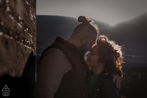 At sunset in the Basque Country in France, the couple stood together, their profiles glowing in the rim-lit rays of the sun, as they shared a tender and warm embrace, capturing the essence of their upcoming marriage.
