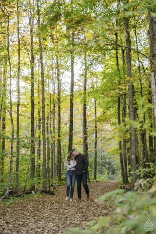 在佛蒙特州曼彻斯特春分度假村的春分池塘，这对即将结婚的夫妇在拍摄订婚肖像时在树林里漫步。