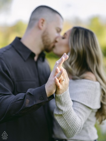 Im Equinox Resort in Manchester, Vermont, präsentiert das verlobte Paar stolz seinen Schmuck, wobei der Fokus auf den ineinander verschlungenen Händen und dem funkelnden Ring im Vordergrund liegt.
