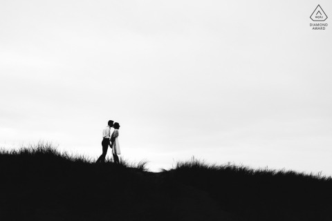 À Labenne, en France, des silhouettes sur la dune capturées dans un cliché minimaliste en noir et blanc montrent le couple dans une tendre étreinte, se préparant pour leur prochain mariage.