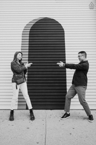 During their engagement portrait session in the Art District, LA, the couple struck James Bond poses in front of a painted garage in a stunning black and white image.