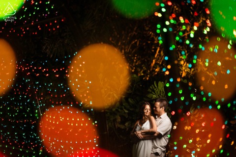 During their nighttime prewedding session in Phuket Thailand, the couple embraced under colorful lights and colorful bokeh, capturing the essence of their love before their upcoming wedding.