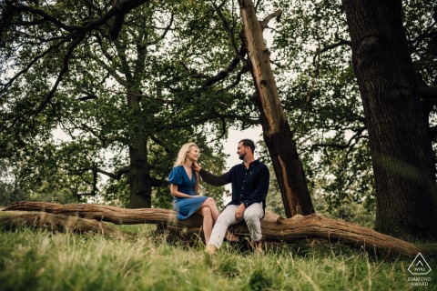 At Pembroke Lodge in Richmond, the couple posed sitting together on a fallen tree and near the grass for their pre-wedding photos.