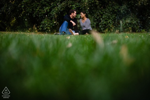 The couple sat together on the grass at Victoria Park in Bath while the photographer took a picture from a low angle.