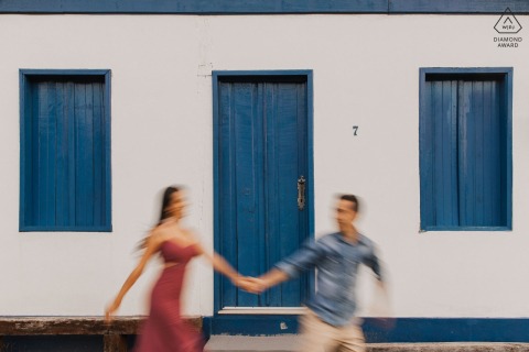 During their engagement photo shoot in Diamantina, MG, the couple was captured running together in front of a beautiful house with a blurred effect using a slow shutter.