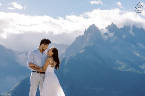 In Chamonix, Französische Alpen, ein Paar in den Bergen, das lacht und sich umarmt und die Liebe und Aufregung vor seinem bevorstehenden Hochzeitstag festhält.