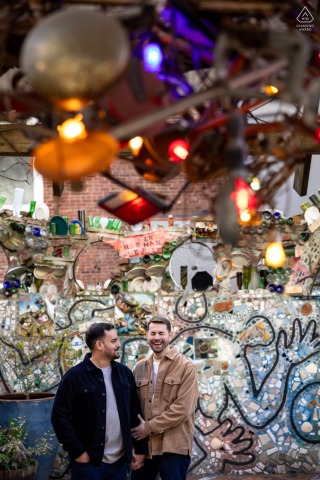 At Magic Gardens in Philadelphia, a happy couple posed for engagement photos, smiling and laughing as a photographer captured their love before their wedding.