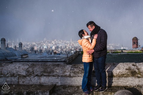 A couple in love had a photoshoot in Istanbul near an ancient stone wall with a city view to celebrate their upcoming wedding.