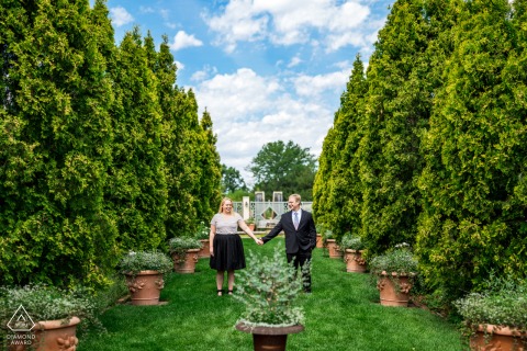 In Denver Botanic Gardens, a photographer took a picture of a couple in the peaceful gardens, where they stood in poses in front of green plants with a style called 'Brenizer'.