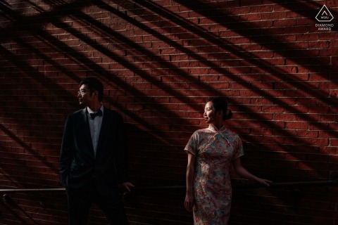 In Boston, a couple had their portraits taken while standing in the afternoon light, casting shadows on the red brick wall behind them.