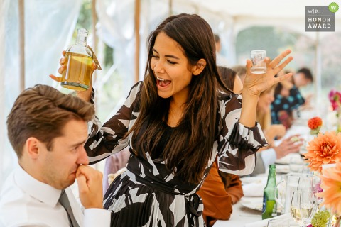 Funny wedding photo from the 10 Castle street wedding venue of a woman offering shots to a man