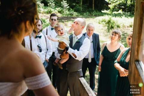 The son of the wedding couple reaches for his mother before the wedding ceremony at Shangri La Farm. Starksboro, VT