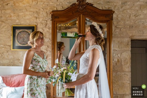 The bride drinks Whisky from the bottle at Chateau de Puissentut, Homps, Gers, France