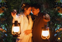 Um retrato de casamento romântico capturado em um local para casamentos em Mosela. Os noivos ficam frente a frente à noite, segurando lanternas com os braços estendidos. Uma cena de amor e intimidade em seu dia especial.