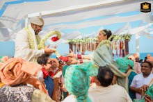 In Caesar Palace, Dubai, de varmaal-uitwisselingsceremonie van een Zuid-Indiase bruiloft waarbij de bruid en bruidegom hoog worden opgetild door hun vrienden en familie en elkaar op de meest leuke manier moeten slingeren!