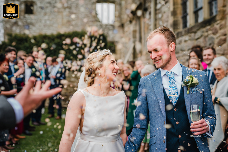 Trouwfoto genomen in The Priests House, Barden, Yorkshire, waarop de bruid en bruidegom door confetti lopen.