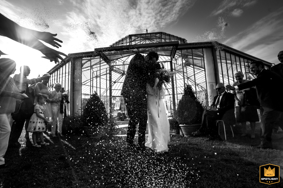 Wedding photo taken at Villa di Bagno in Porto Mantovano, Mantova, capturing a black and white image from a low angle during the rice throwing ceremony.