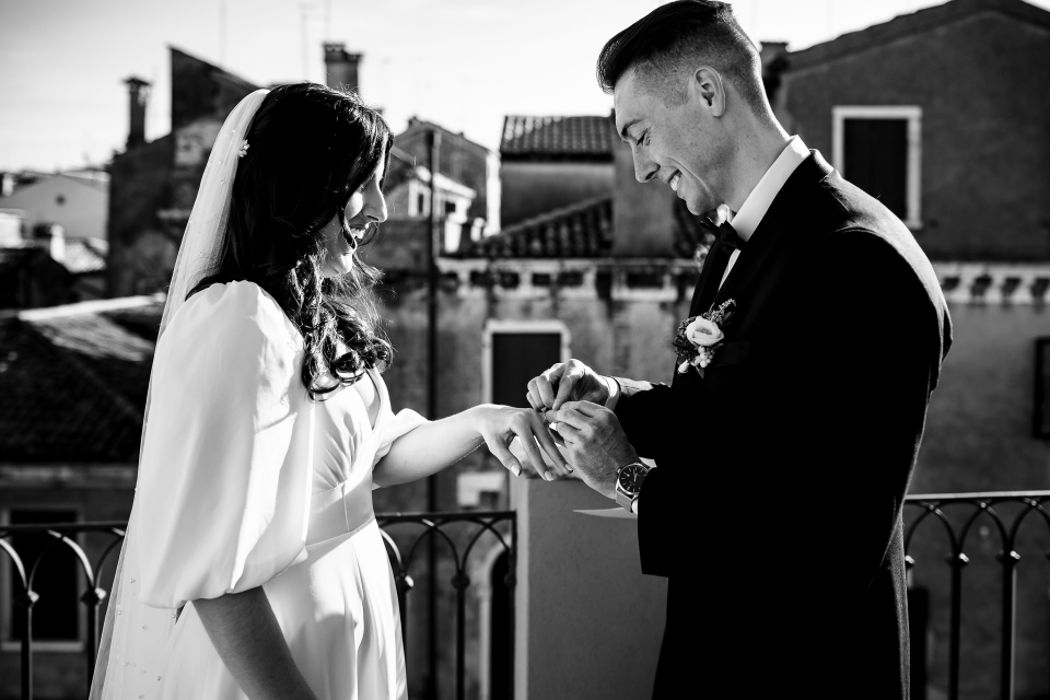 In Venice during a Private Balcony wedding, the bride and groom exchange rings - Photography by Davide Cristin